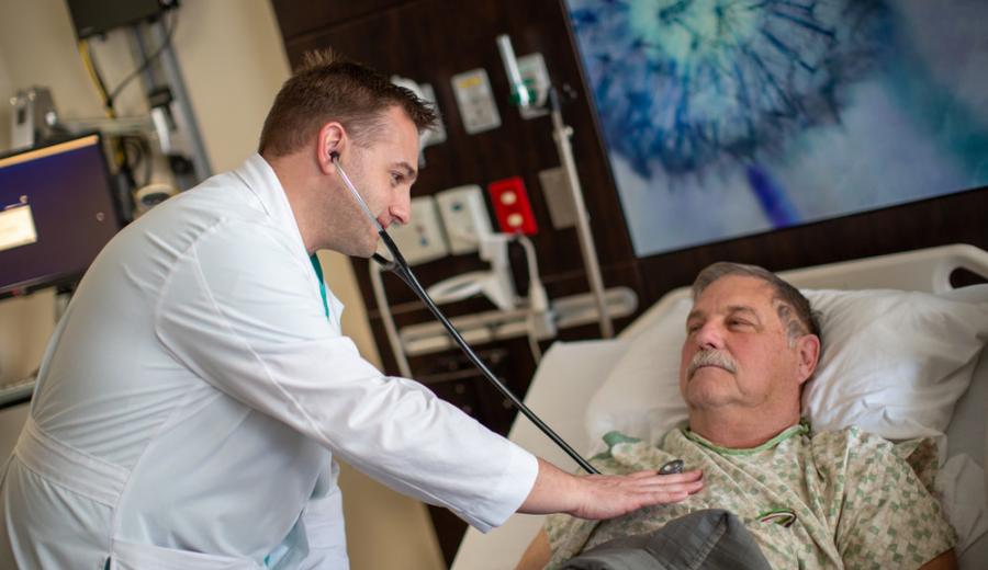 Jeffrey Arnzen, MD, listens to a patient's heart