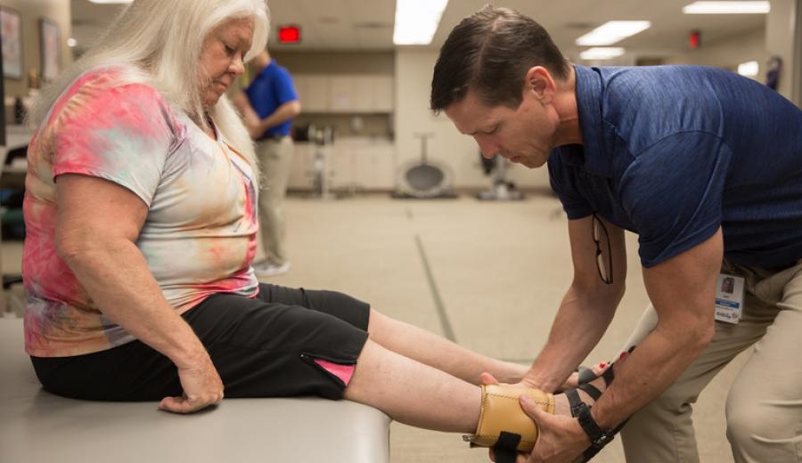 Methodist physical therapist Pat Wilson, PT, OCS, CSCS, fitting a brace on a patient.