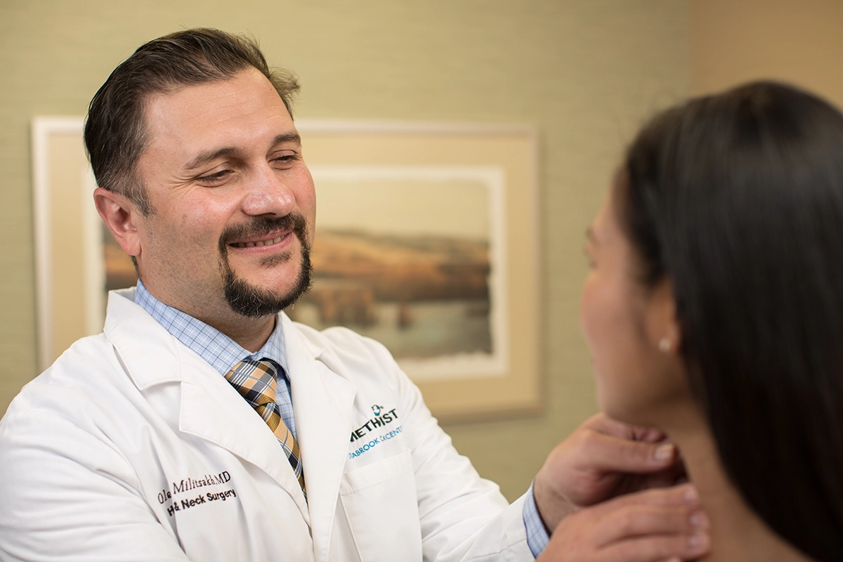 Oleg Militsakh, MD, of Head and Neck Surgical Oncology exams a patient at Methodist Estabrook Cancer Center.