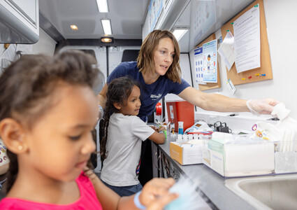 Kiley Petersmith and pediatric patient on mobile health unit