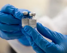 Person holding COVID-19 vaccine vials