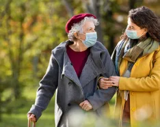 Older woman walking with young woman in park