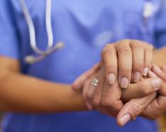 Nurse holding a patient's hand