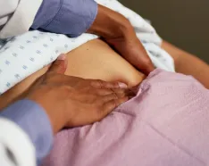 Photo of physician pressing a patients midsection
