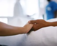 Holding hands in hospital bed