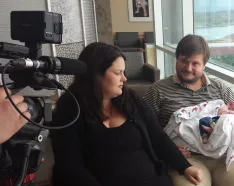 Brand new parents with baby being interviewed