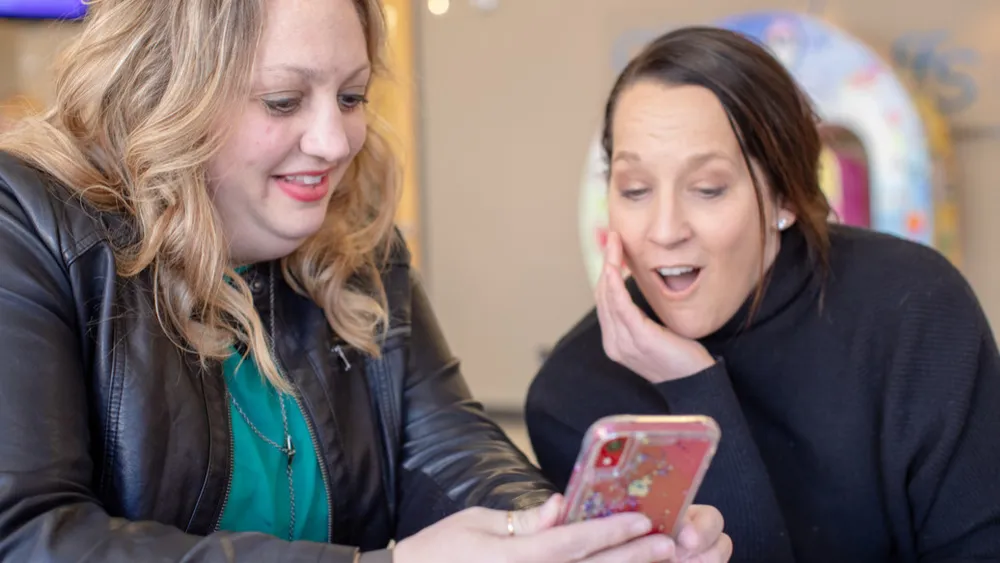 Photo of JoAnn Jensen showing a photo on her phone to Lori Platt, MD
