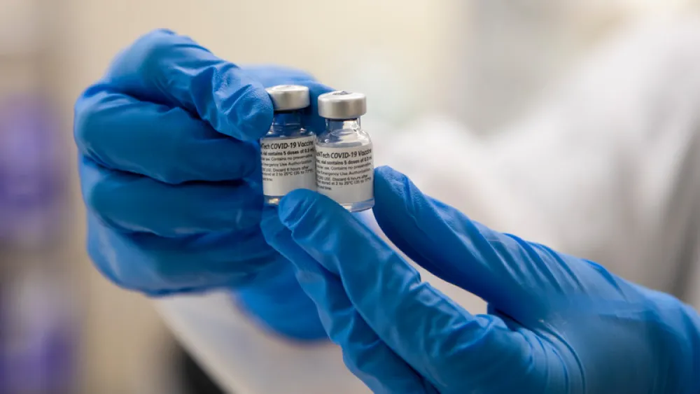 Person holding COVID-19 vaccine vials