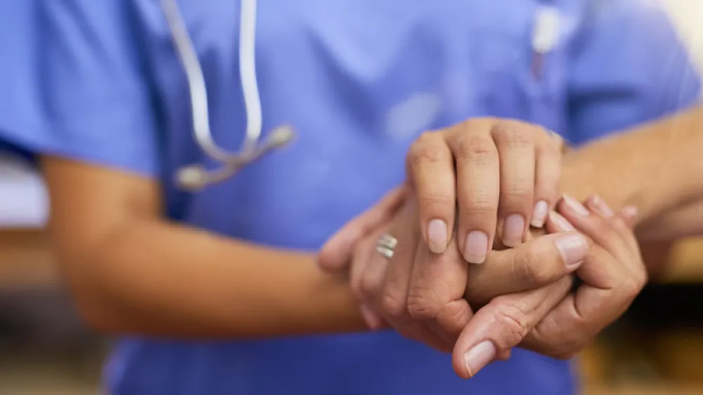 Nurse holding a patient's hand
