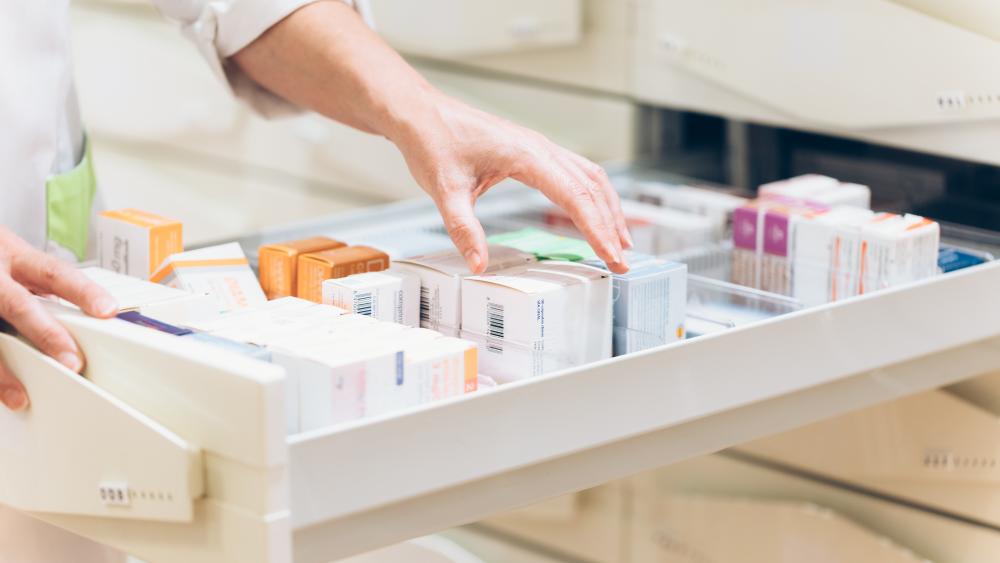 Pharmacist taking medicine from drawer