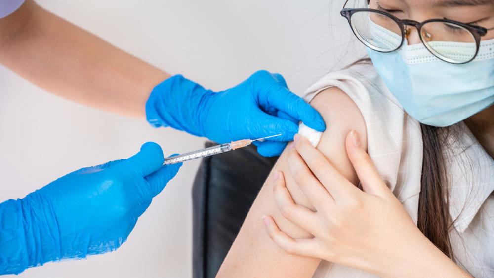 Teen receiving COVID-19 vaccine