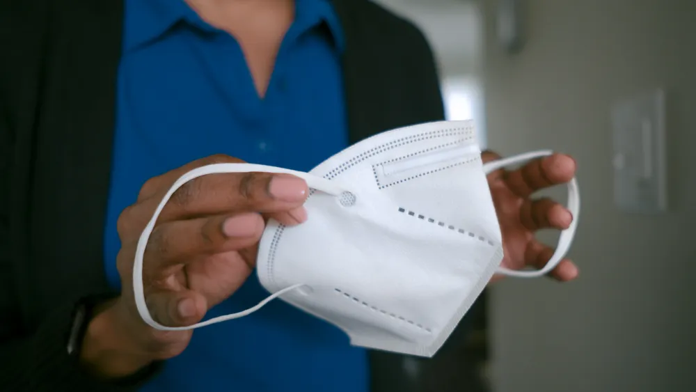 Image of a healthcare provider holding a KN95 mask