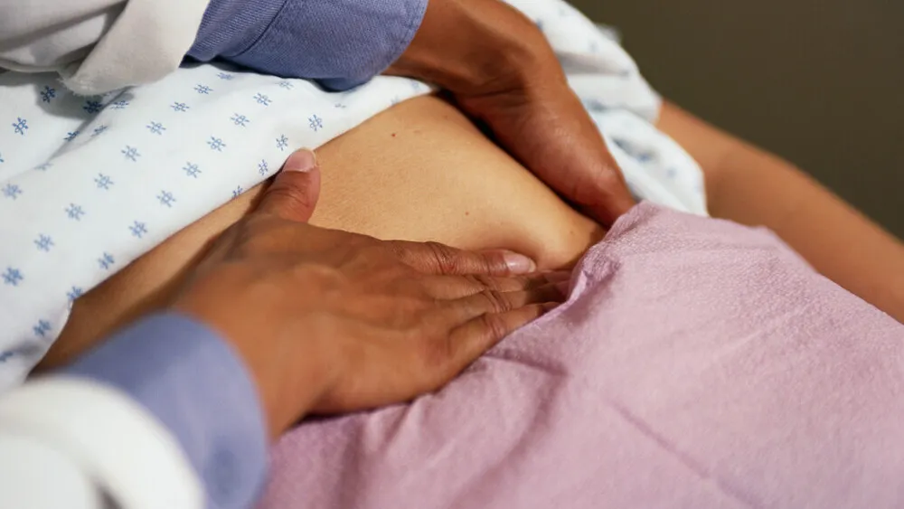 Photo of physician pressing a patients midsection