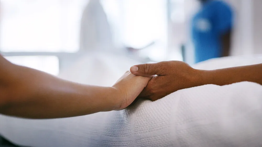 Holding hands in hospital bed