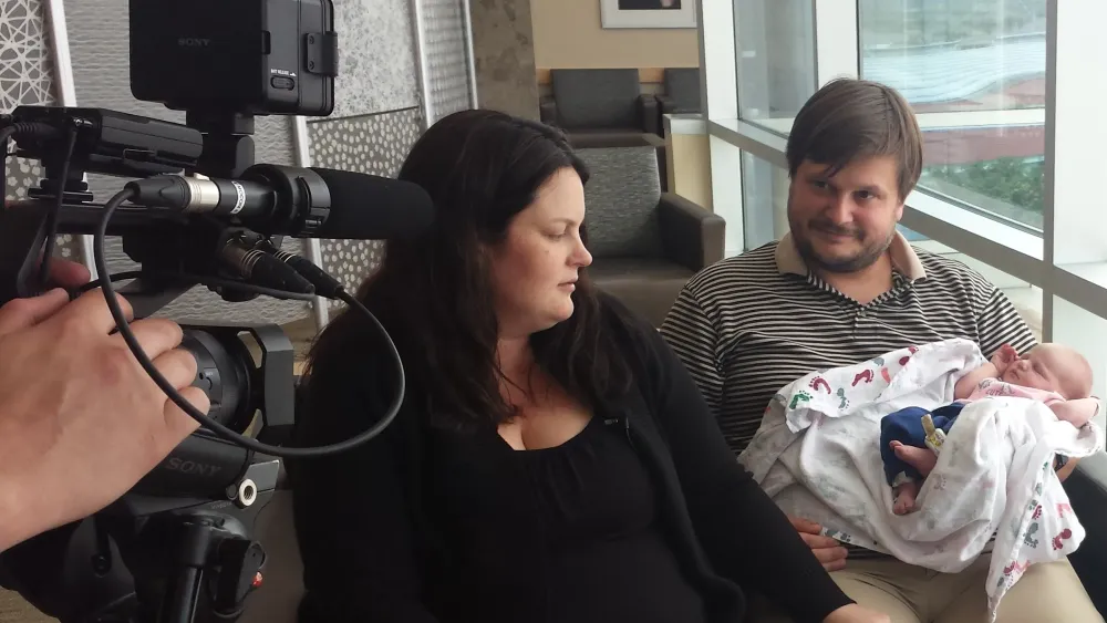 Brand new parents with baby being interviewed