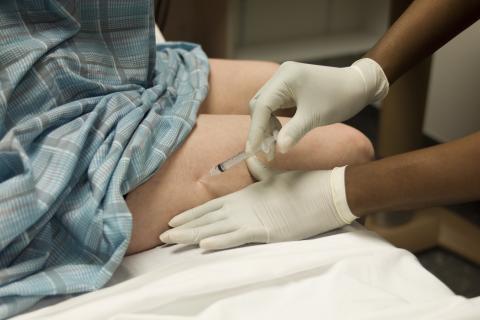 Patient getting vaccine in leg