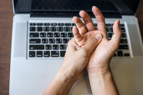 Woman holding her wrist pain from using computer