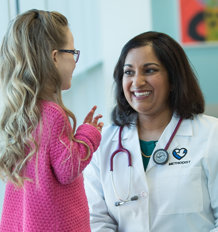 Photo of Dr. Rosann Nichols chatting with a young patient